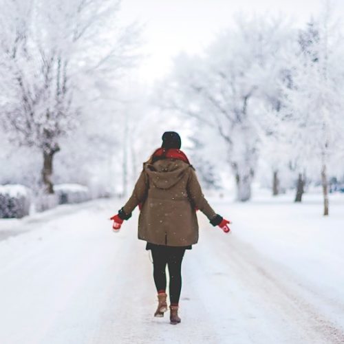 Woman walking down snowy street