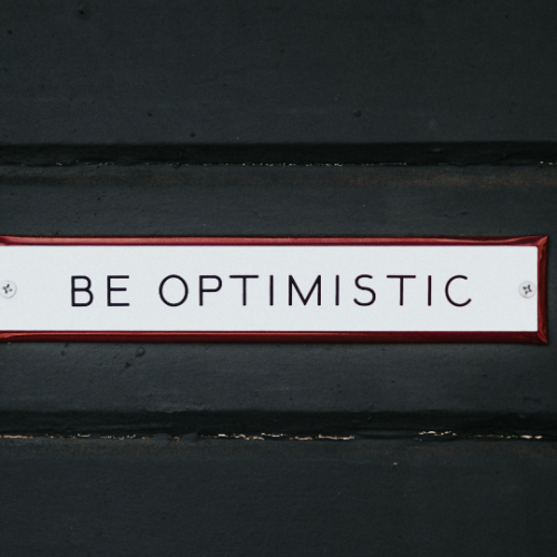 be optimistic sign on a black door