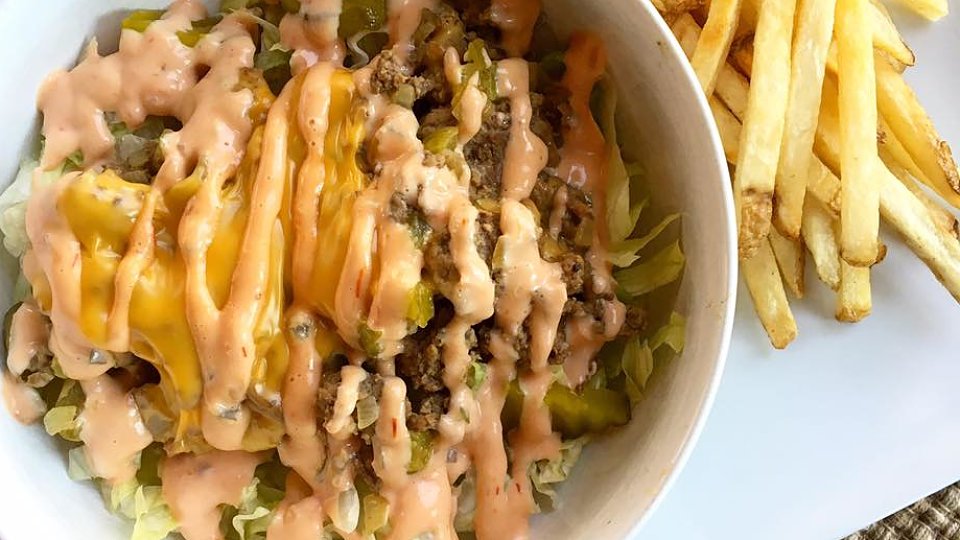 Big Mac salad in a bowl with fries on the side