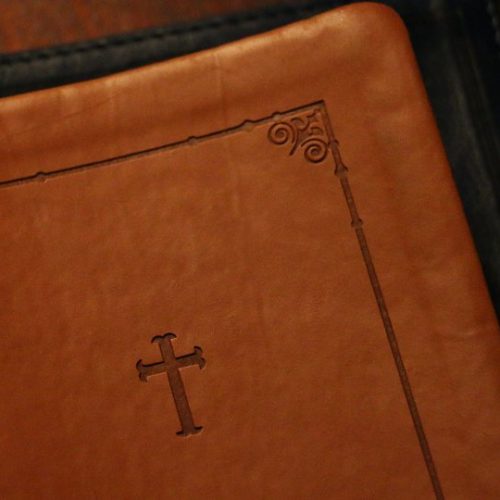 brown leather Bible with a cross on it