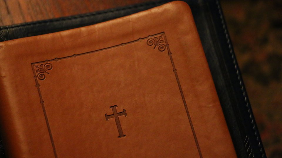 brown leather Bible with a cross on it