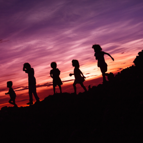 kids playing walking in a line during sunset