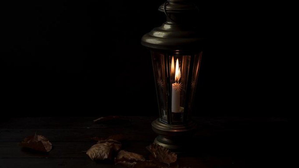 an old lantern in a dark room sitting on table