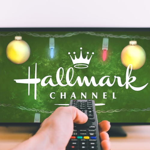 person holdinng remote pointing it at the tv with the hallmark channel on