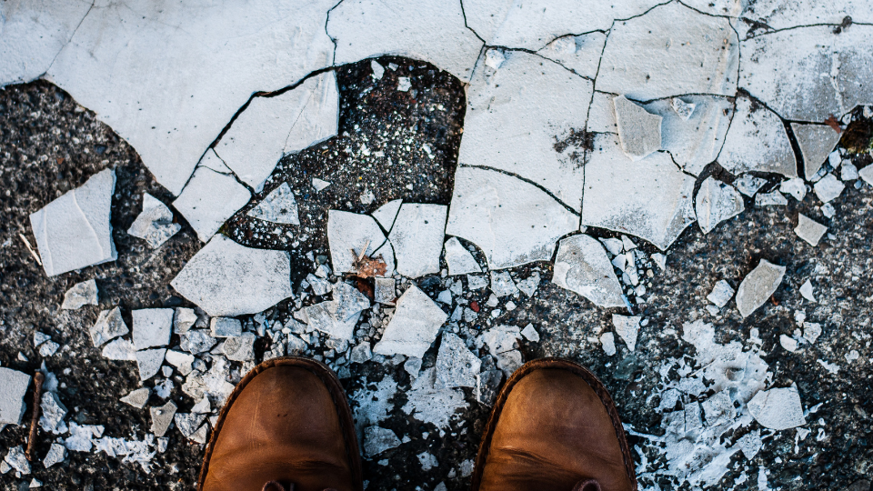 brown boots standing over broken concrete