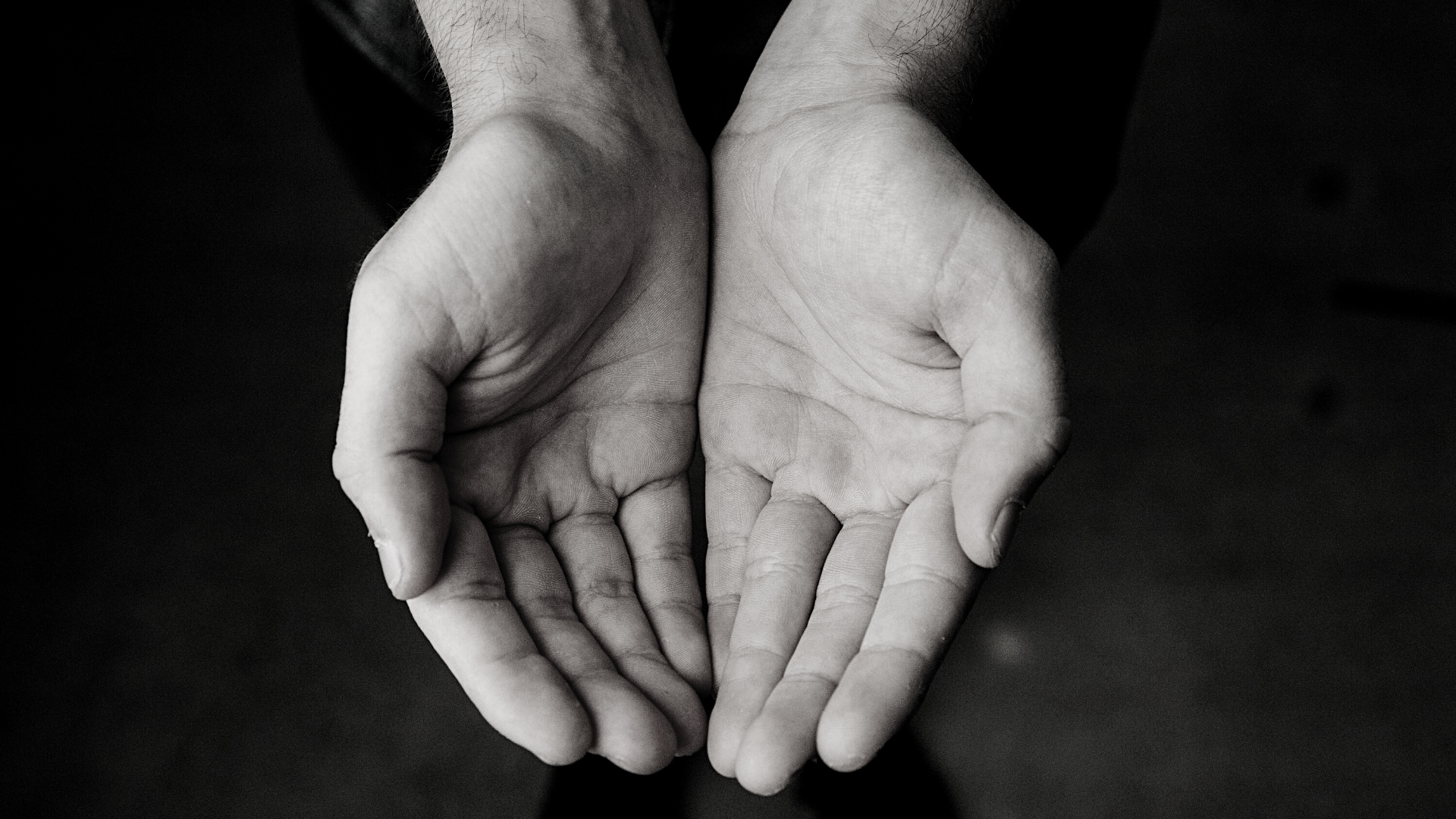 black and white picture of two hands cupped together and extended ready to receive something