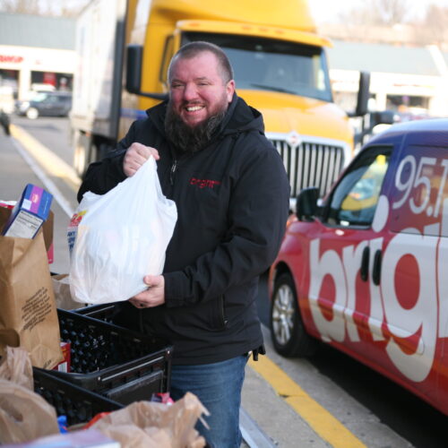 Smiling man holding bag of groceries