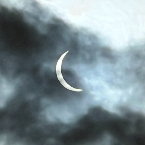 A photo of the partial eclipse through clouds
