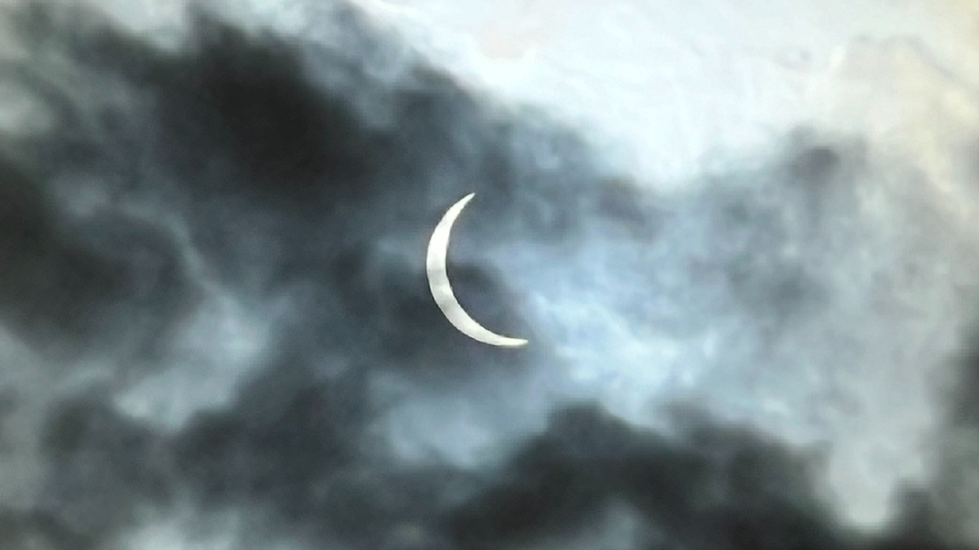 A photo of the partial eclipse through clouds